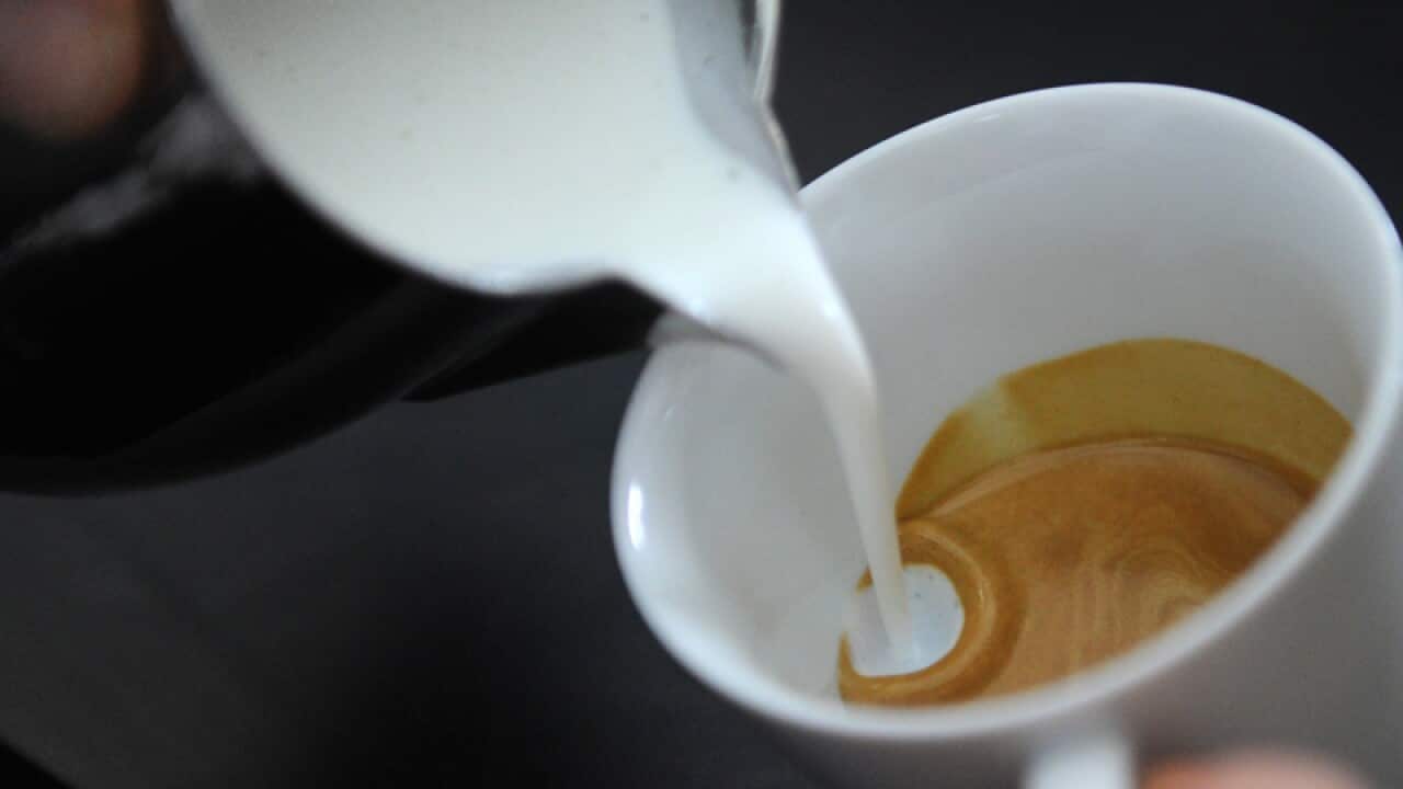 A barista makes coffee