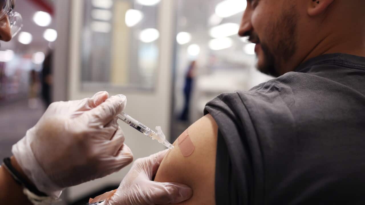 A man receiving a vaccination administered by a nurse.