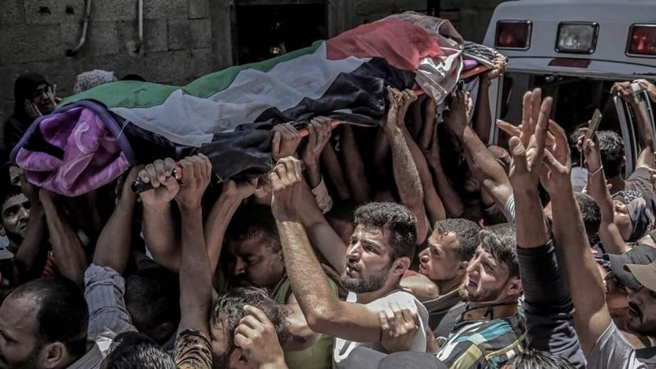 Palestinian mourners carry the body of Razan al-Najar,