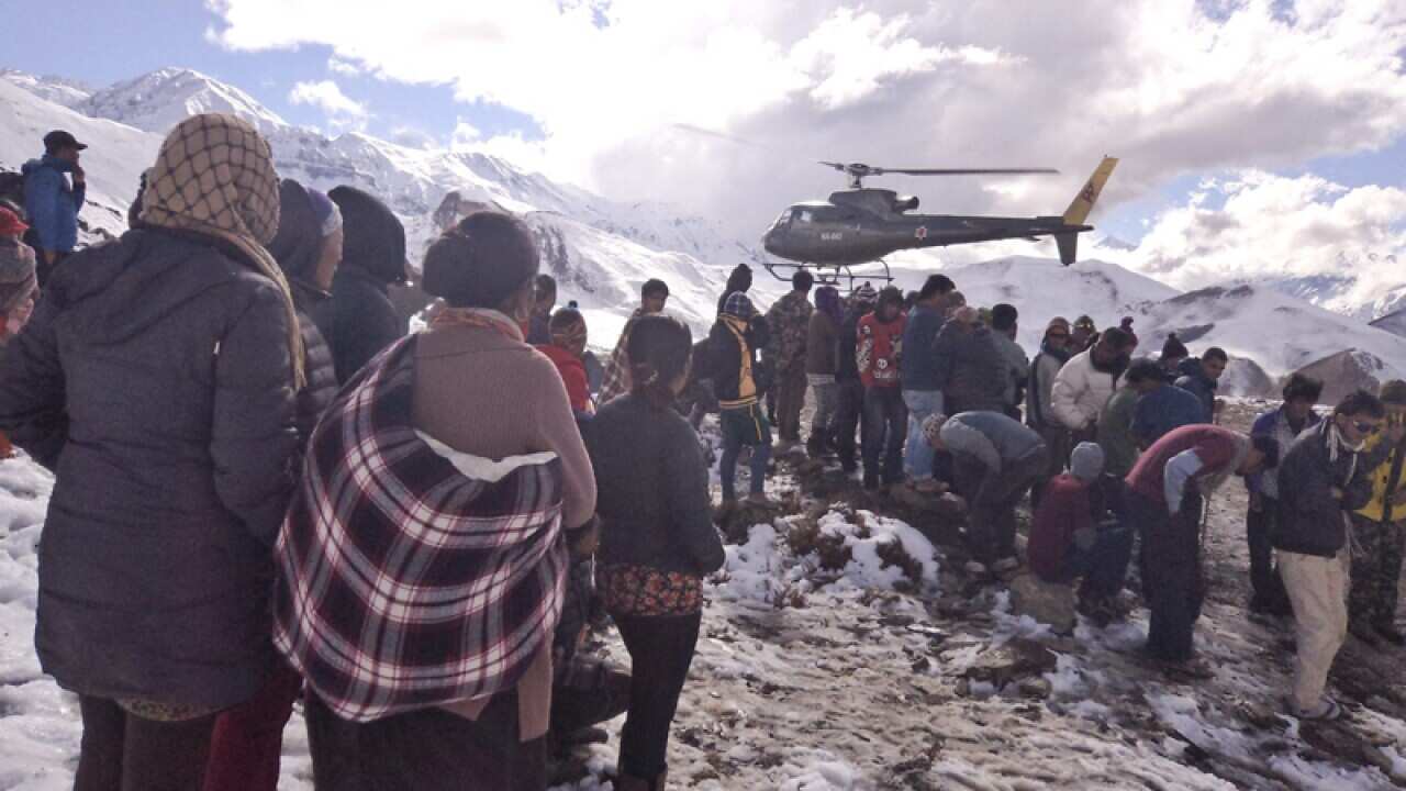 People gather as a Nepalese army rescue helicopter arrives.