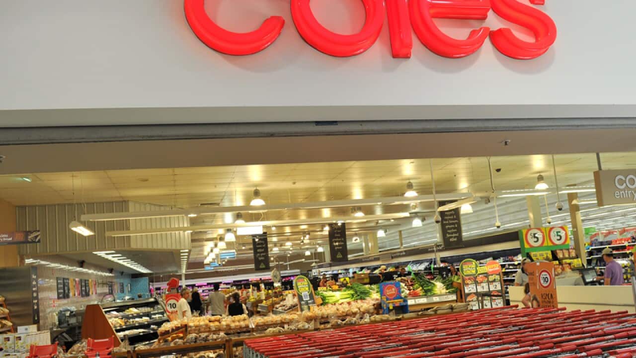 Shopping trolleys sit outside a Coles supermarket