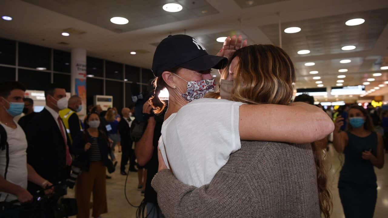 A mother and child hug at Sydney airport