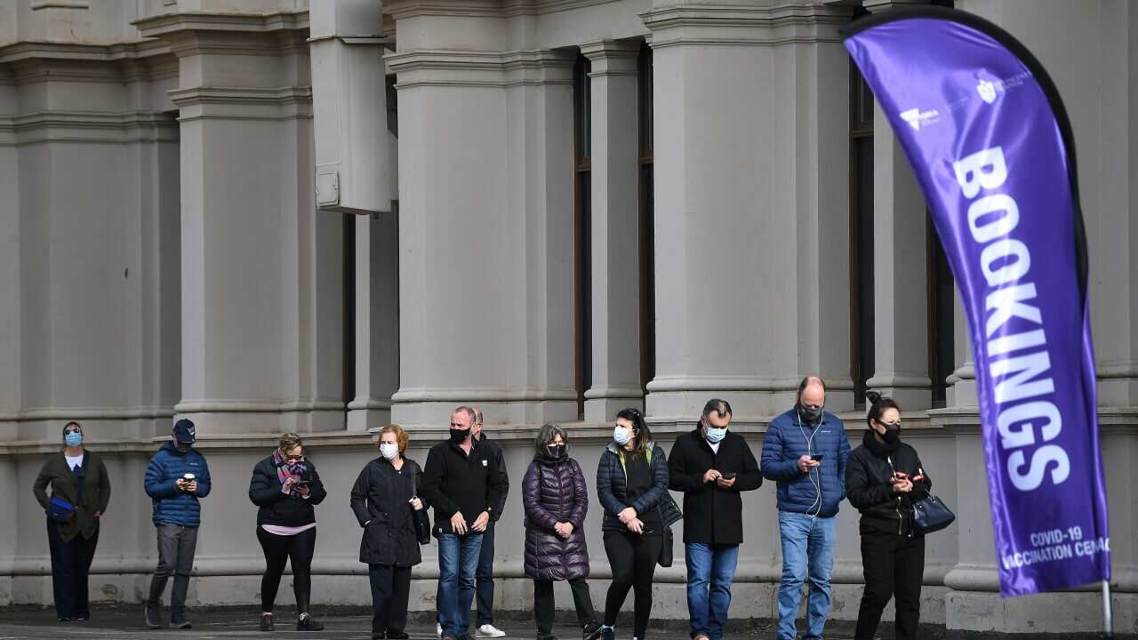 People are seen in a line outside the Melbourne Exhibition Centre coronavirus vaccination hub as a 'Free Melbourne' anti-lockdown protest is expected to take place in Melbourne, Saturday, June 5, 2021. (AAP Image/James Ross) NO ARCHIVING