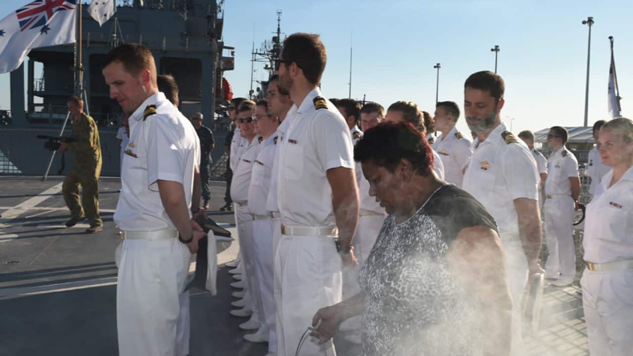 Janet Turner on board HMAS Arunta performs a smoking ceremony