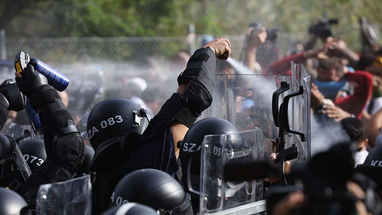 Hungarian riot police fire pepper spray and water cannons as they repel an attempt by migrants to break the border post gate and pull down the razor wire fence on September 16, 2015 in Horgos, Serbia.