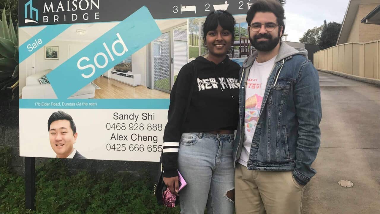 Nav, 24 years old, and his partner standing outside their newly purchased property.