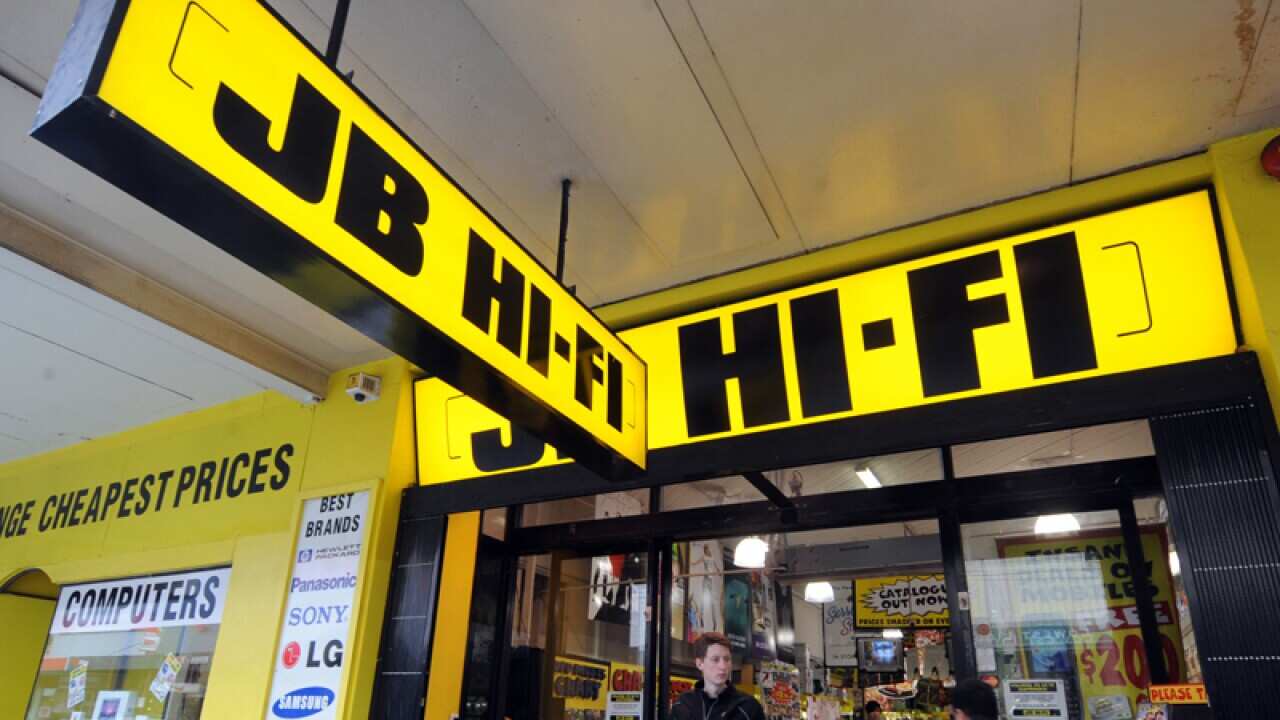 Pedestrains walk past a JB HI-FI store in Melbourne