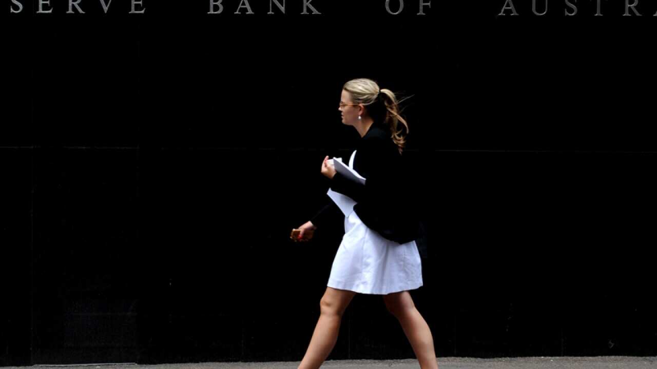 A woman walks past the Reserve Bank of Australia