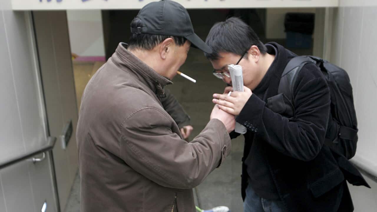 pedestrians smoke outside an underpass in Shanghai