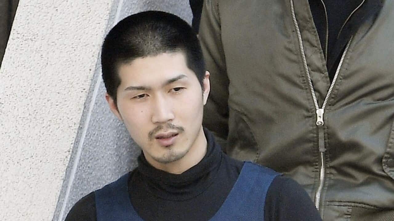 Tatsuma Hirao is escorted by police to be transferred to a police station in Hiroshima on April 30.
