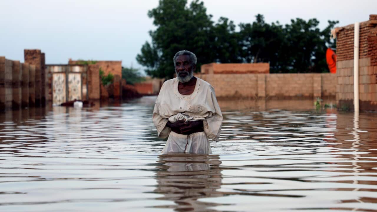 An old man walks in the water after losing his home amid the severe flooding in the Umm Dum area, east of Khartoum