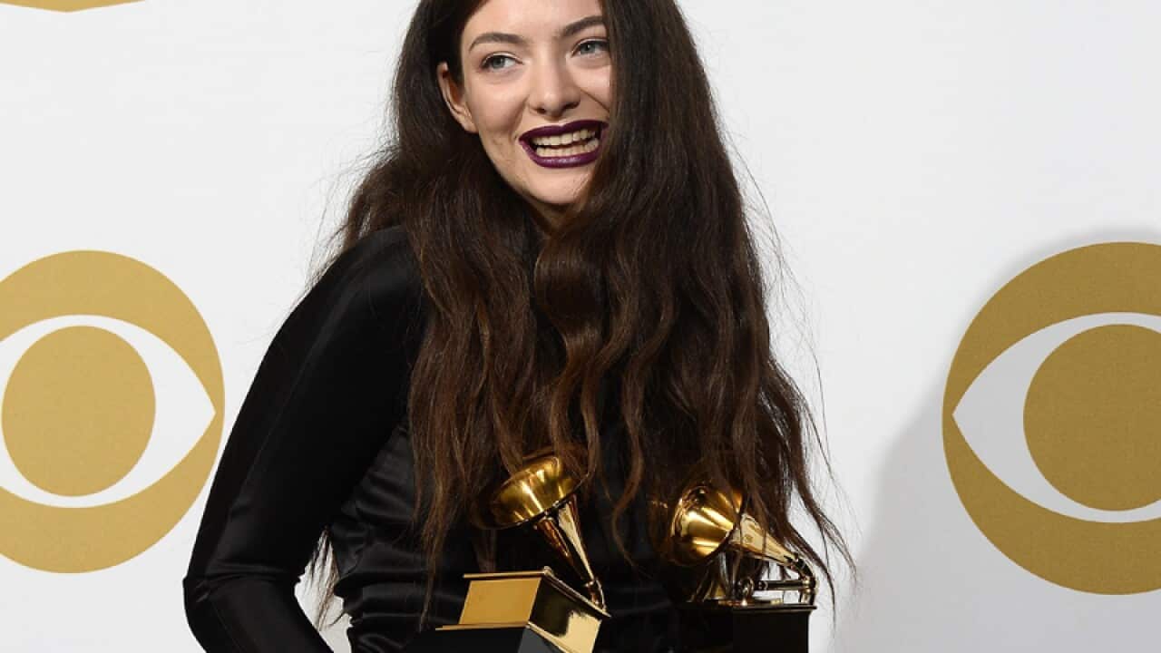 Lorde poses for photos with her Grammy Awards