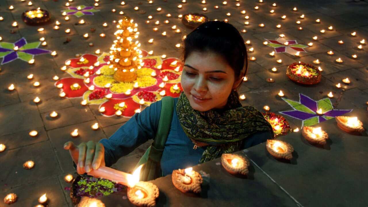 A woman lights Diwali lamps - AAP.jpg