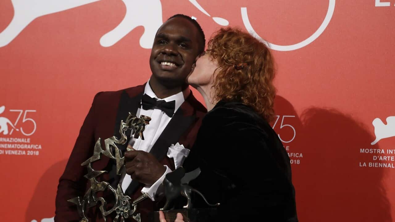 Director Jennifer Kent, right, kisses actor Baykali Ganambarr after winning two awards. 