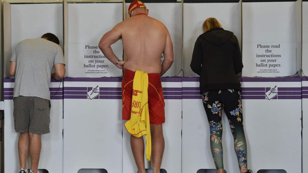 A surf lifesaver (C) casts his ballot in the Wentworth by-election in Bondi Beach in Sydney on October 20, 2018