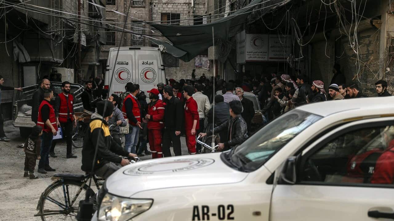 People stands next a mobile clinic f Syrian Arab Red Crescent trucks arrive in Douma, in Eastern Ghouta, Syria, 05 March 2018.