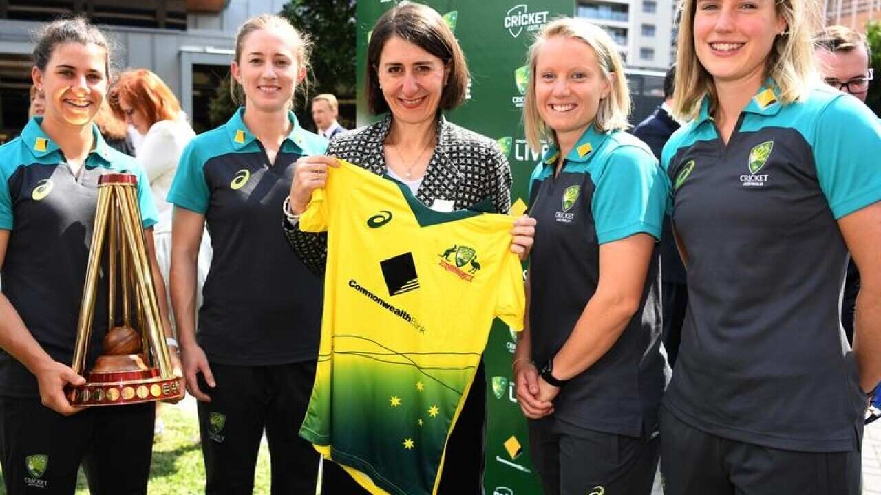 Gladys Berejiklian holds an Australian women's cricket team shirt