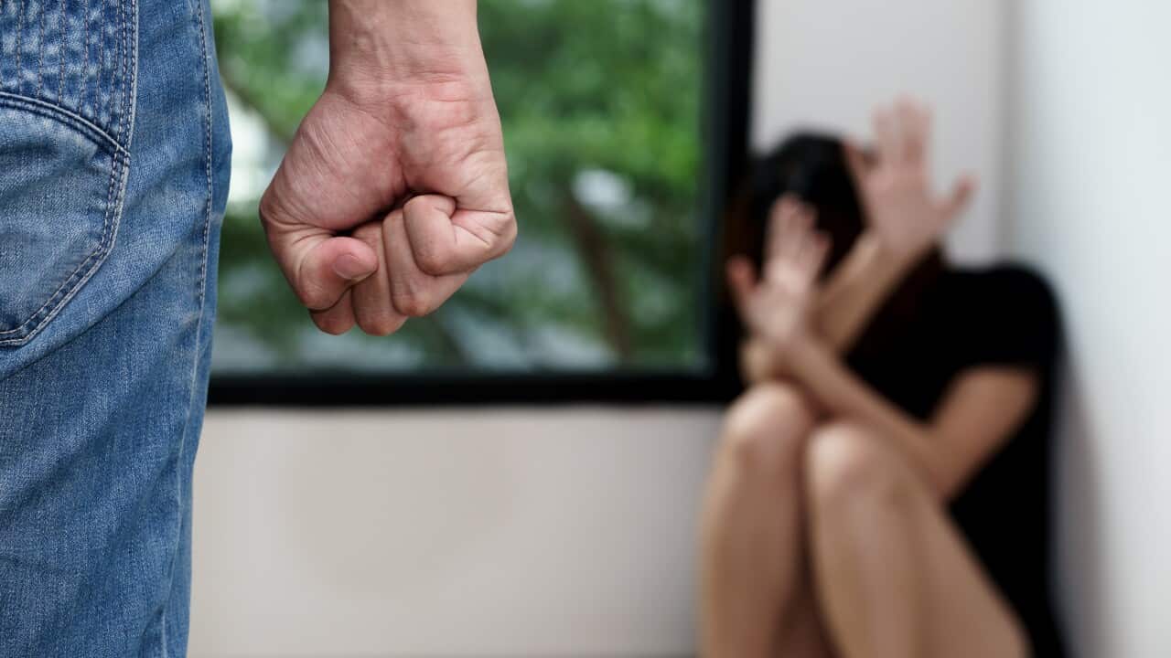 Midsection Of Man Harassing Woman Sitting Against Window At Home
