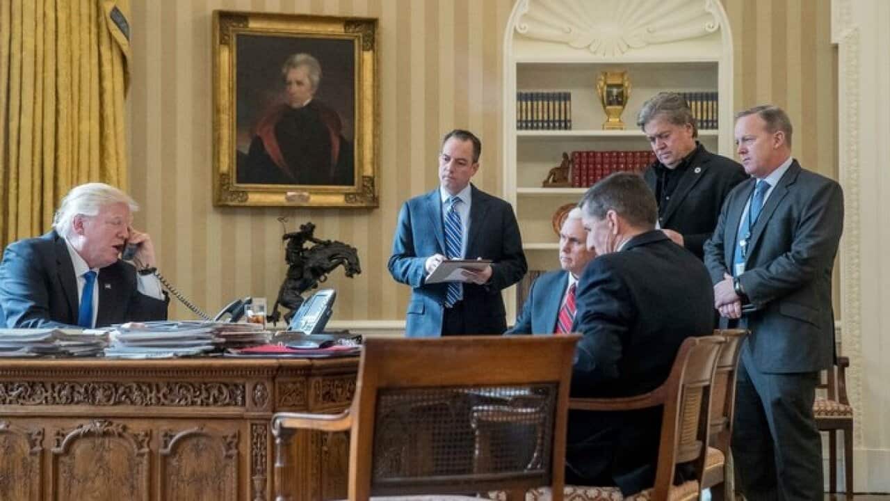 President Donald Trump, along with current and former staffers, including Steve Bannon (second from right)