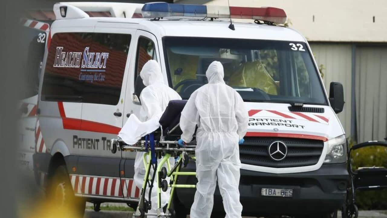 Health workers remove resident from St. Basil's aged care in Fawkner.