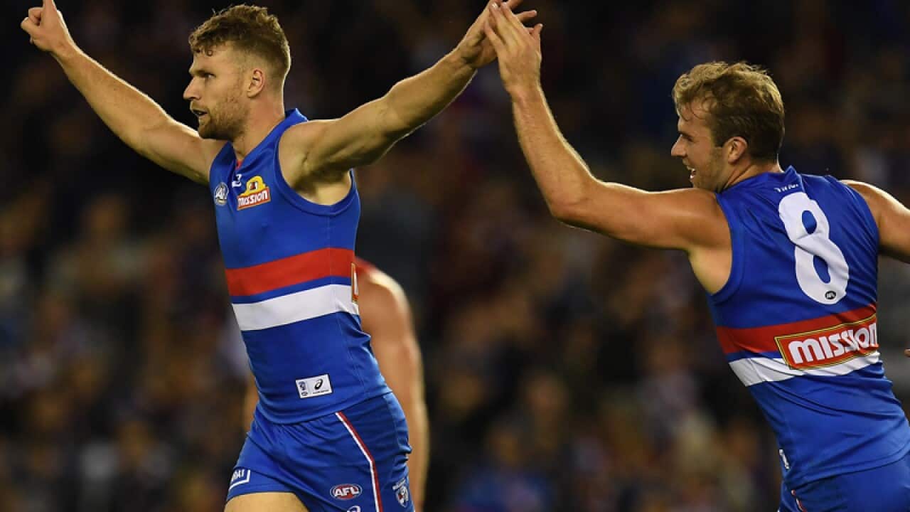 Jake Stringer of the Bulldogs (left) reacts after kicking a goal