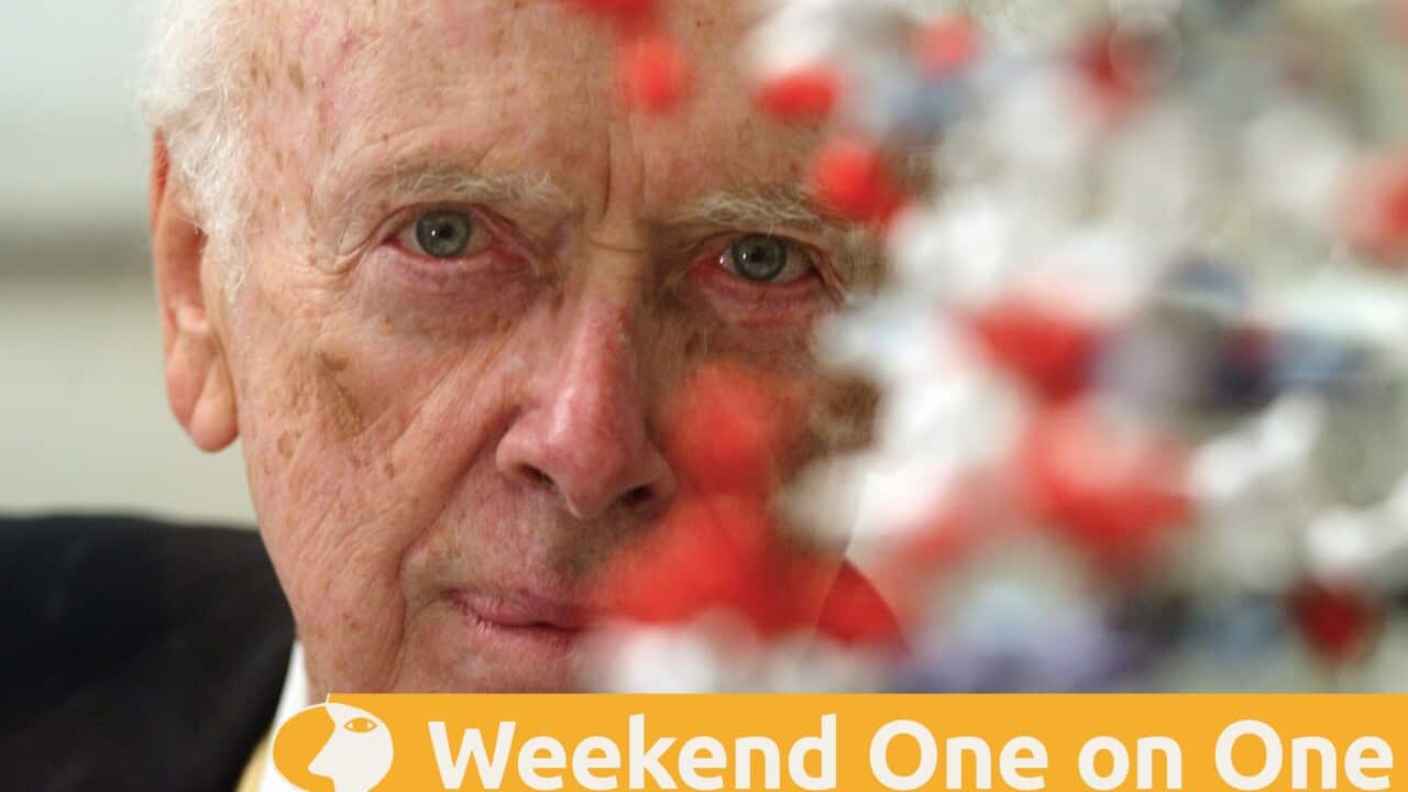 James Watson seen behind a model of a DNA molecule