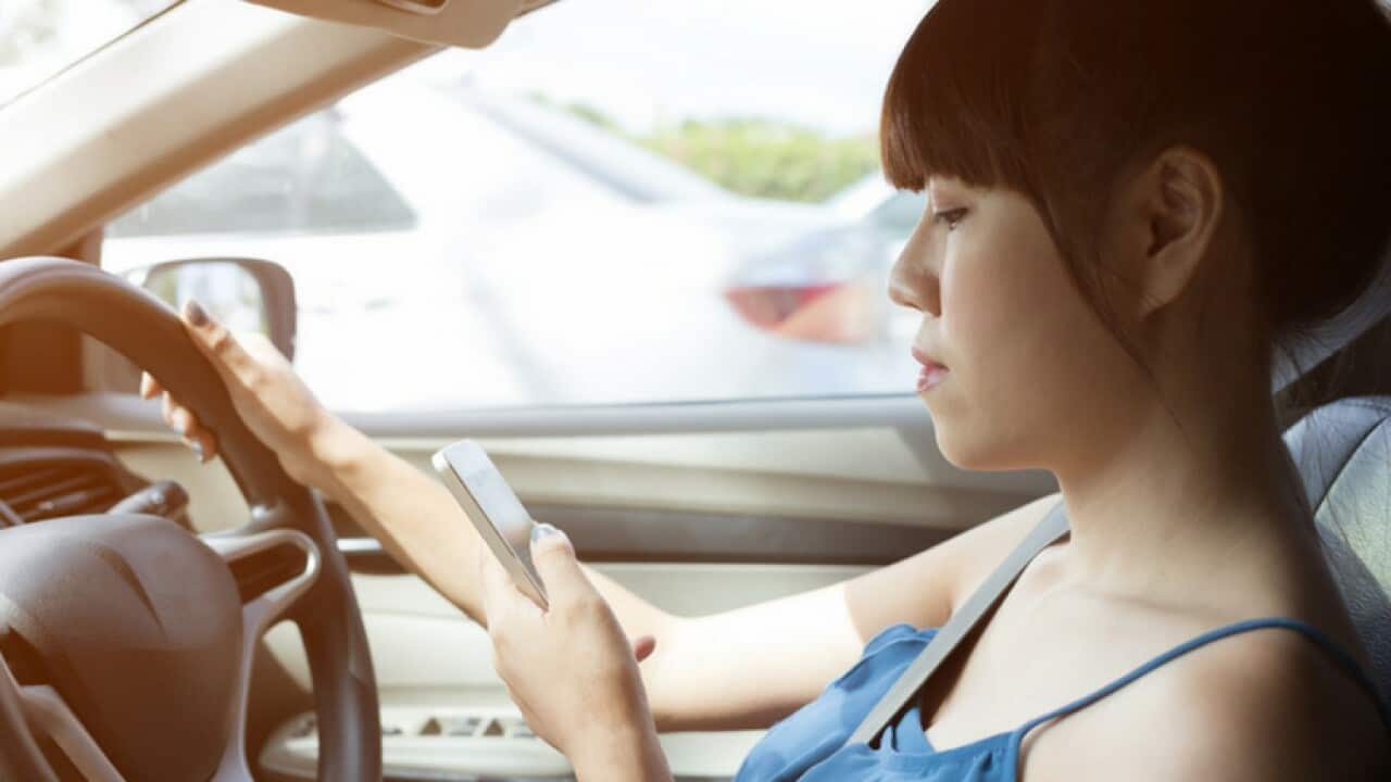 a-female-driving-using-her-mobile-phone.jpg