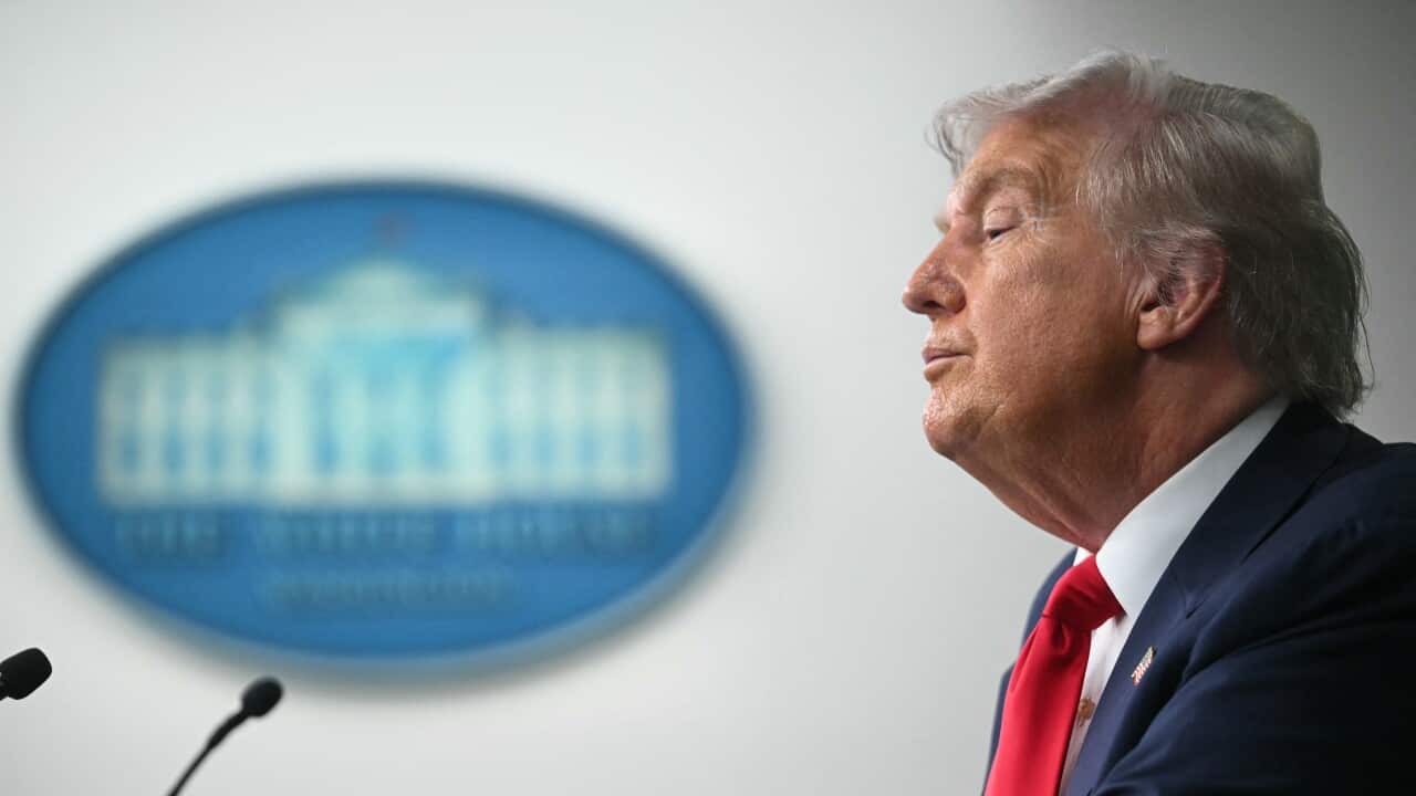 A side profile of Donald Trump speaking into a microphone.