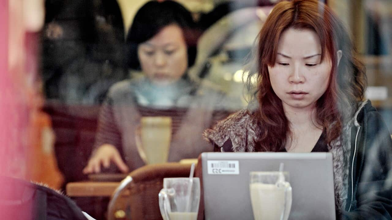 A woman looks at her laptop worried.