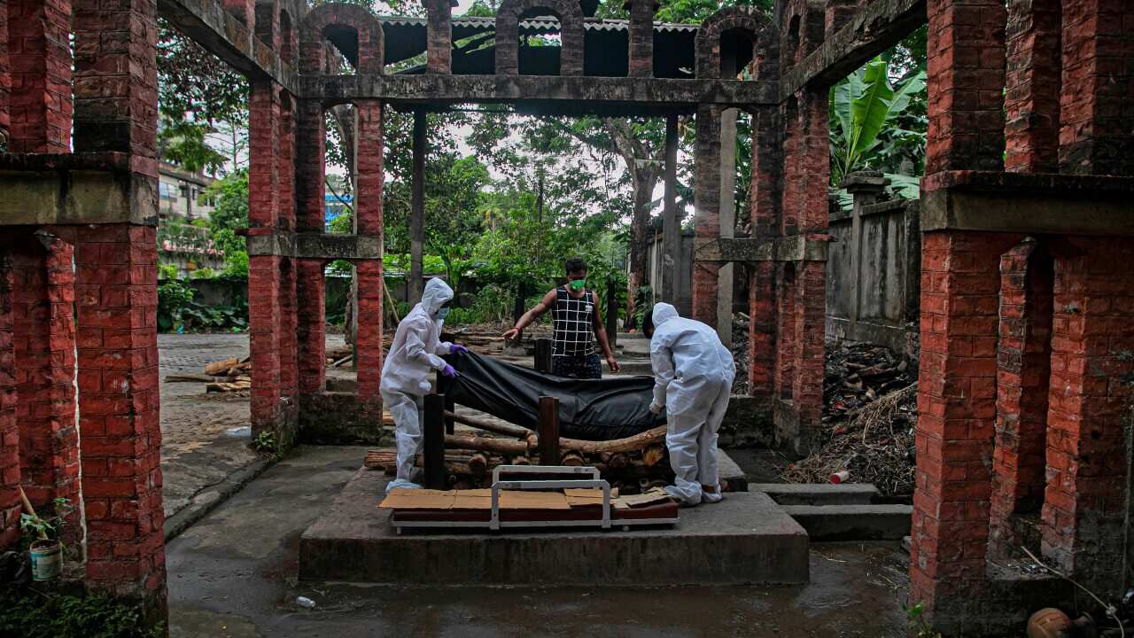 Ramananda Sarkar, 43, gives instruction to health workers before cremating the body of a COVID-19 victim in India, on 15 September.