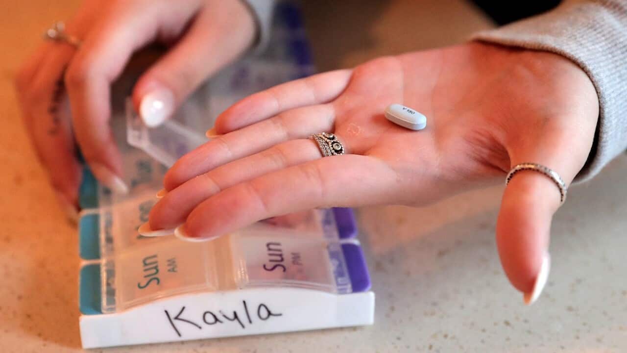 A person is seen with a pill on their open palm.