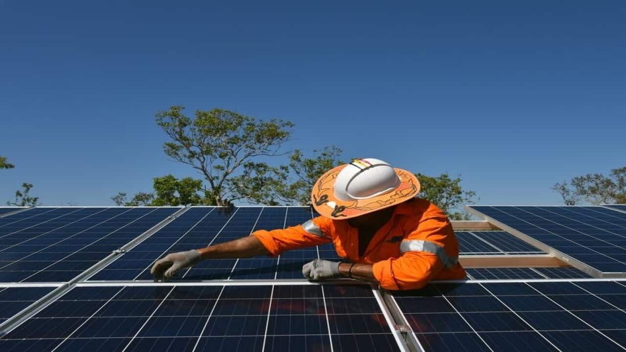 A worker installs solar panels