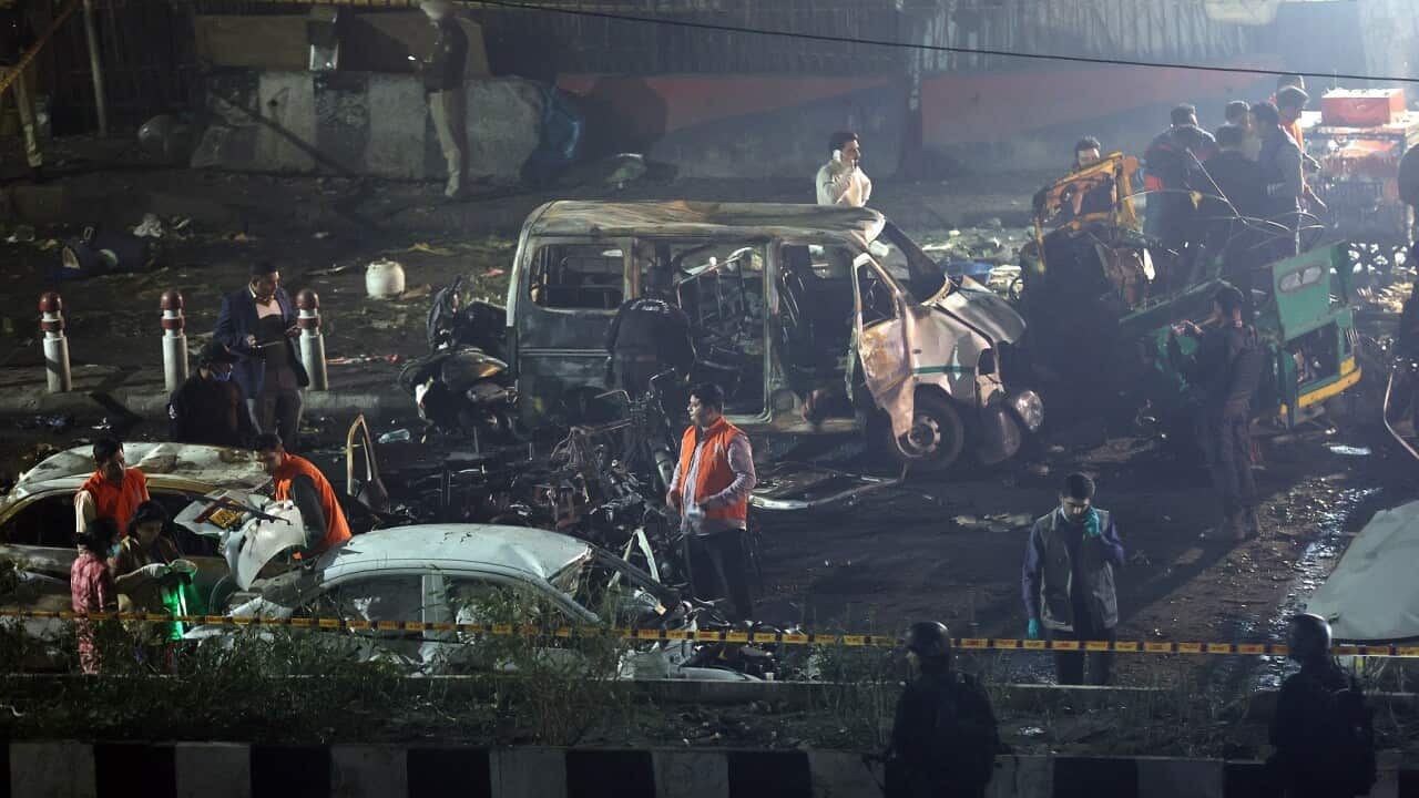 Indian police personnel inspect the scene of a blast near the red fort in New Delhi