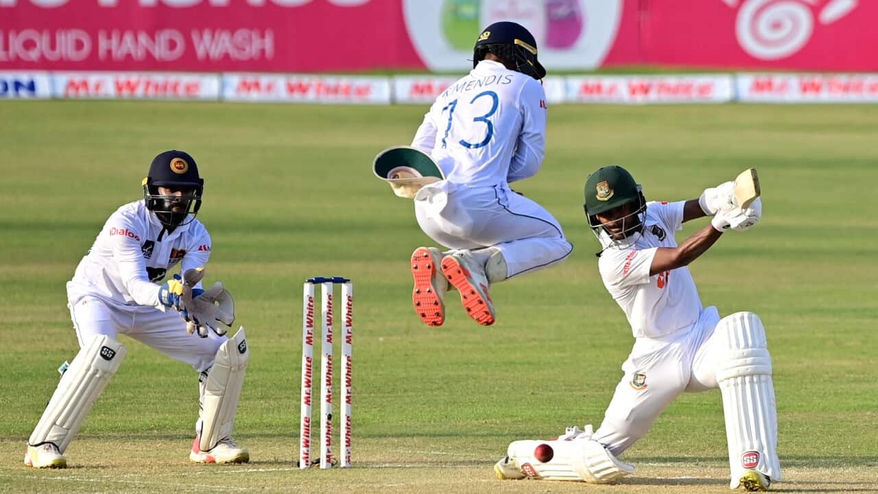 Bangladesh's Mahmudul Hasan Joy (R) plays a shot as Sri Lanka's Kusal Mendis jumps next to wicketkeeper Niroshan Dickwella (L) during the second day of the first Test cricket match between Bangladesh and Sri Lanka at the Zahur Ahmed Chowdhury Stadium in C