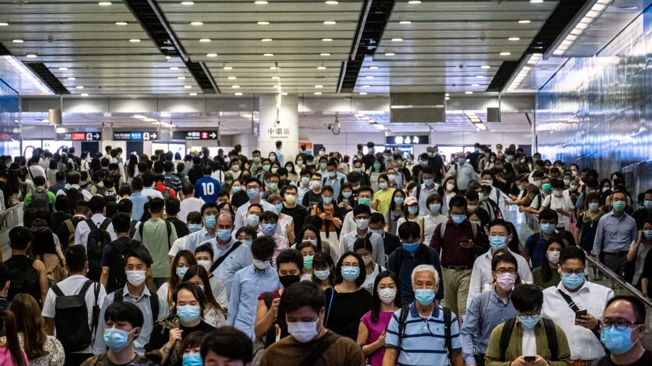 Passengers wearing protective masks walk through the Hong Kong Station.