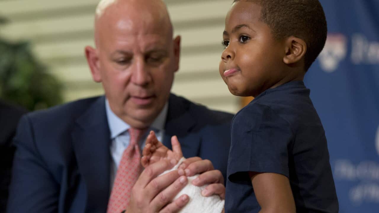 As Dr. L. Scott Levin holds his hand, double-hand transplant recipient eight-year-old Zion Harvey moves his fingers during a news conference Tuesday, July 28, 2015 (AP Photo/Matt Rourke)