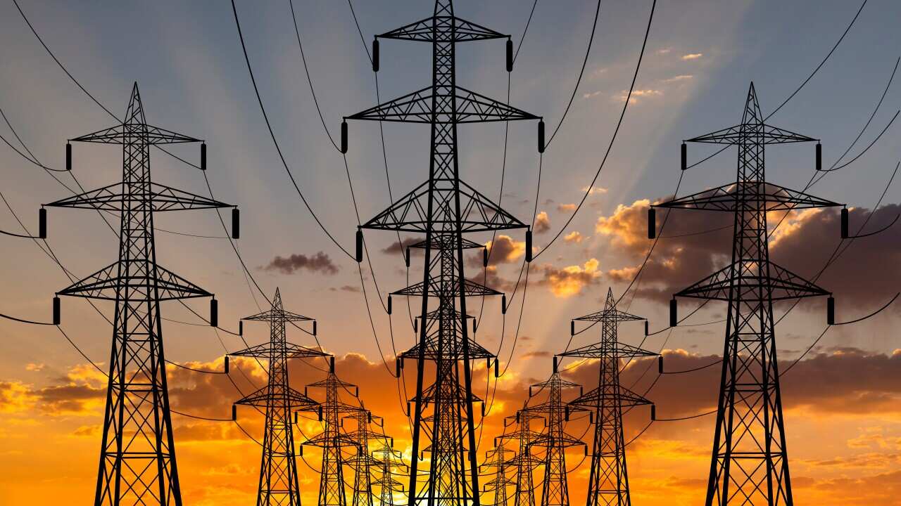High voltage towers at sunset background. Power lines against the sky