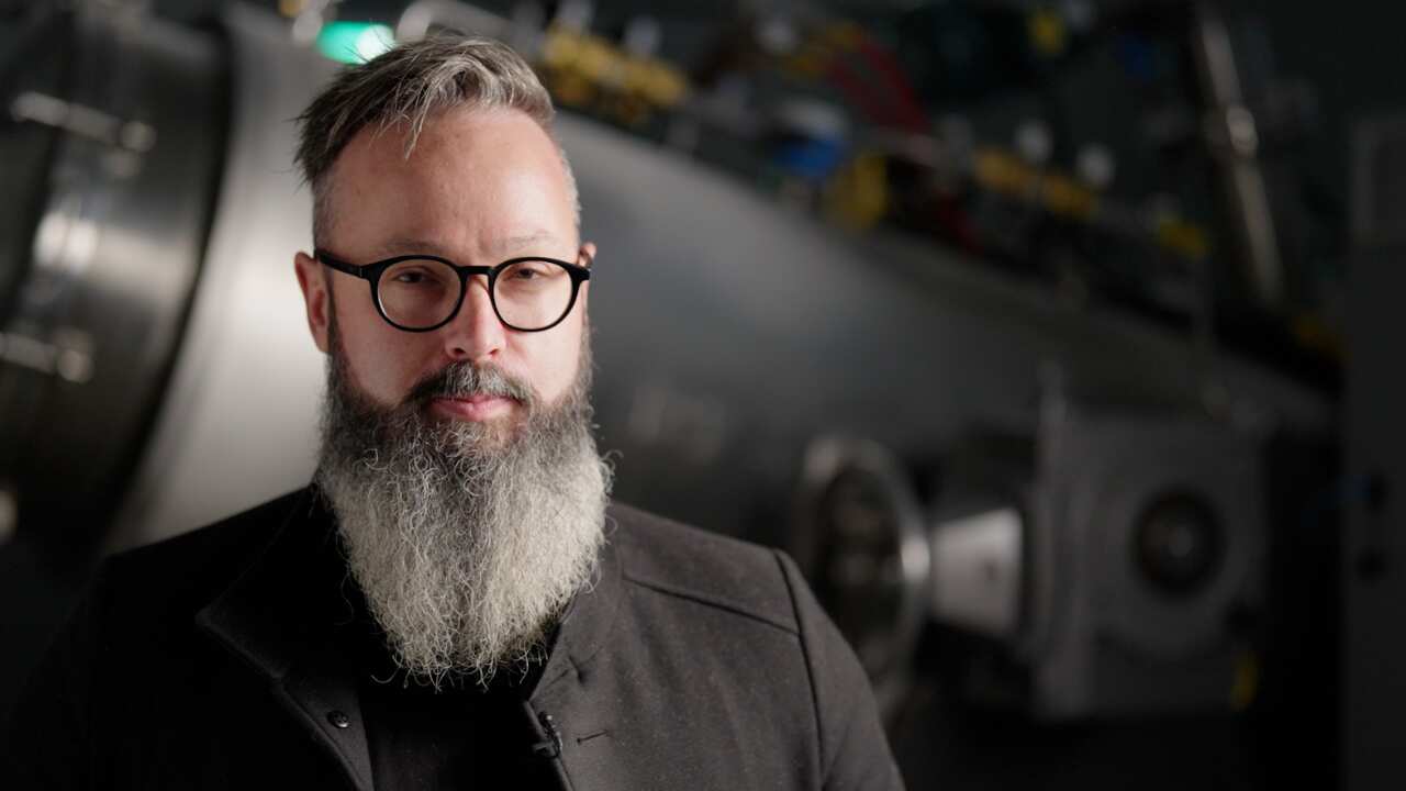 A man looks to screen. 