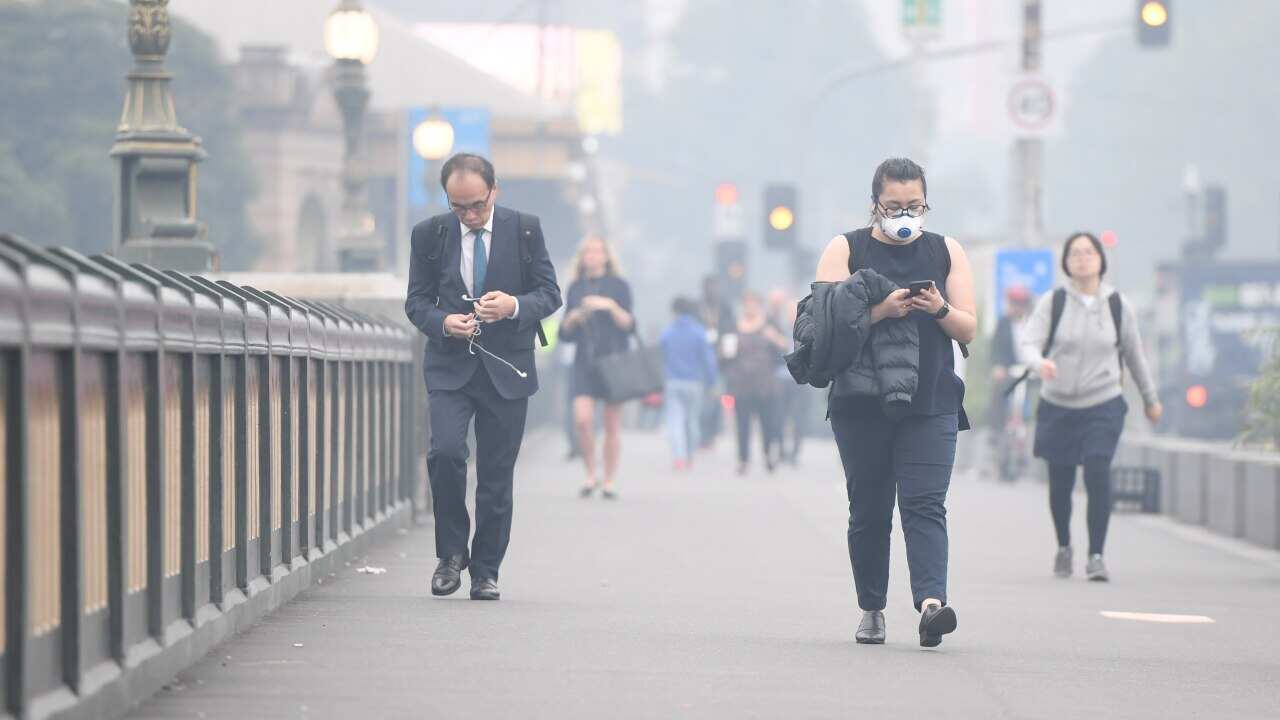 Morning commuters are seen through smoke haze from bushfires in Melbourne, Tuesday, 14 January, 2020.