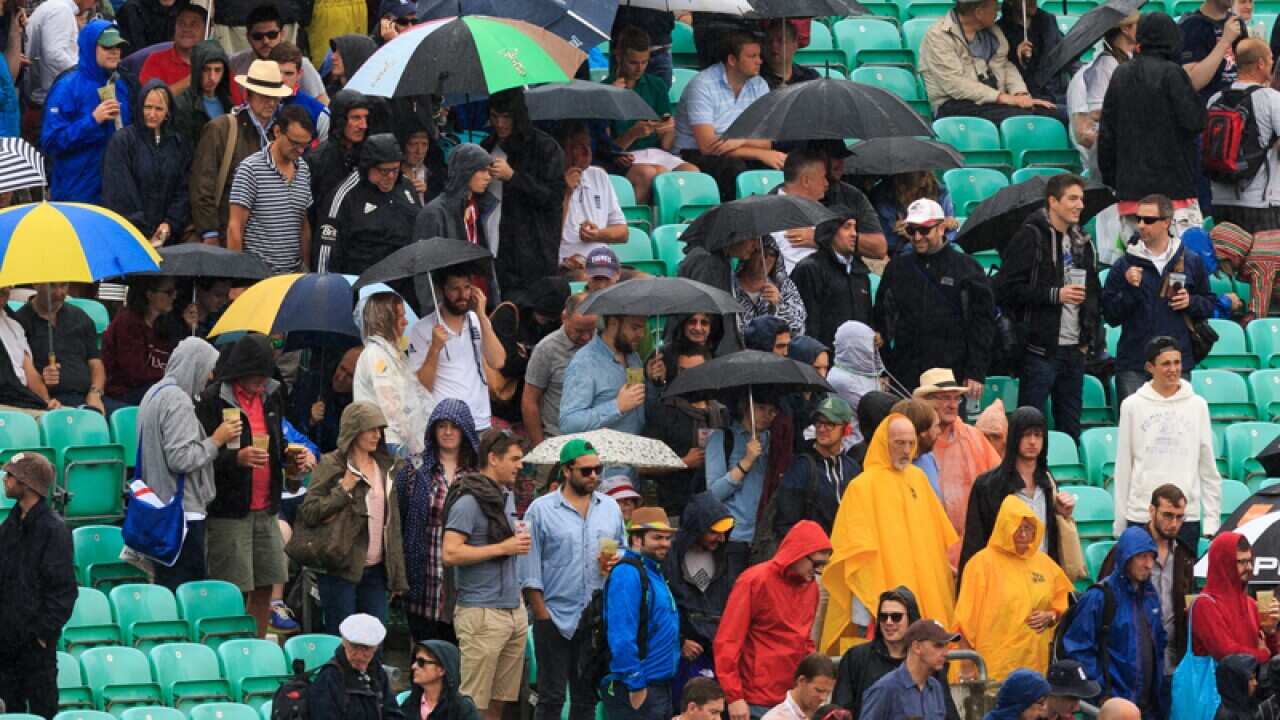 Umbrella's are up in the stands as people start to leave