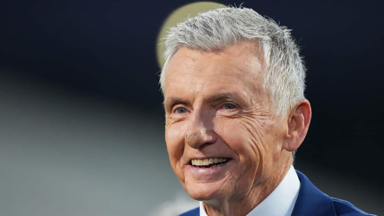 Bruce McAvaney wearing a blue suit and white shirt