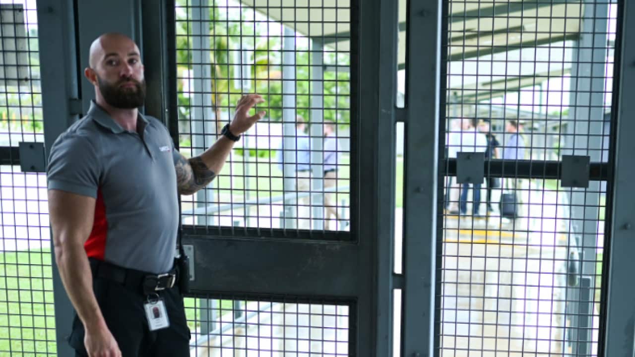 A guard stands at the entry door during a tour of the North West Point Detention Centre on Christmas Island. 