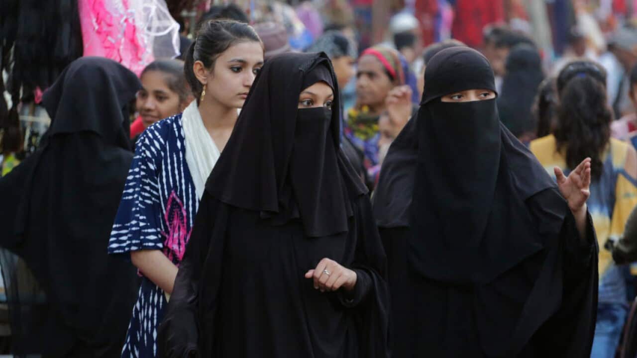 Veiled Indian Muslim women walk through a busy market in Ahmadabad, India, Thursday, Dec. 27, 2018 (AAP)