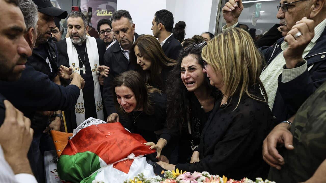 Colleagues cry over the corpse of veteran Al Jazeera journalist Shireen Abu Akleh.