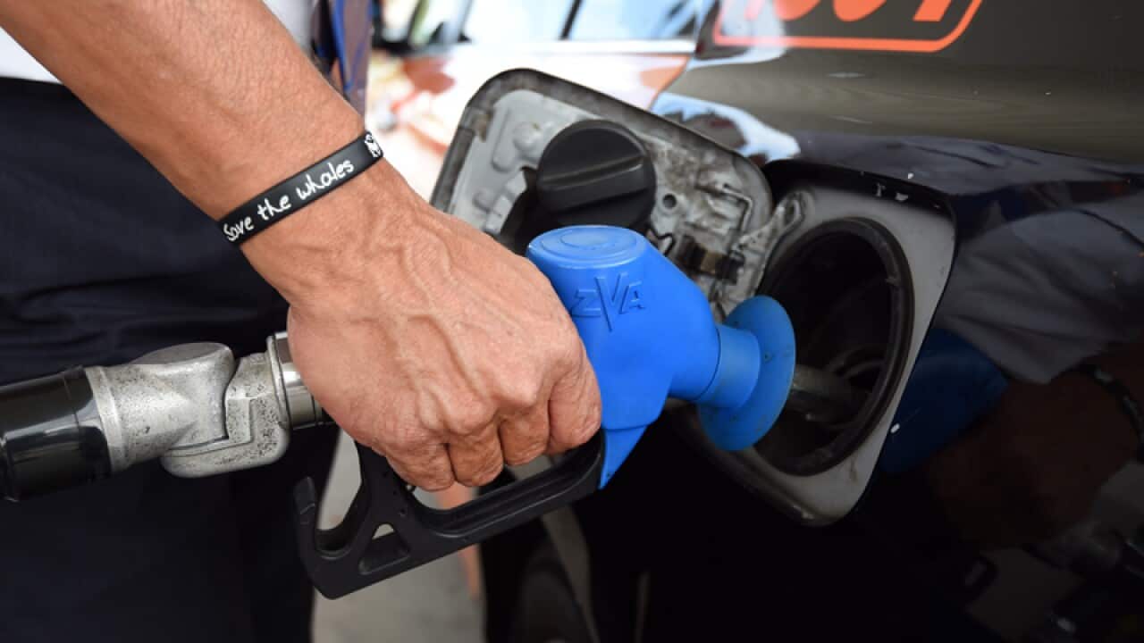 A motorist refuels his car at a service station in Brisbane.