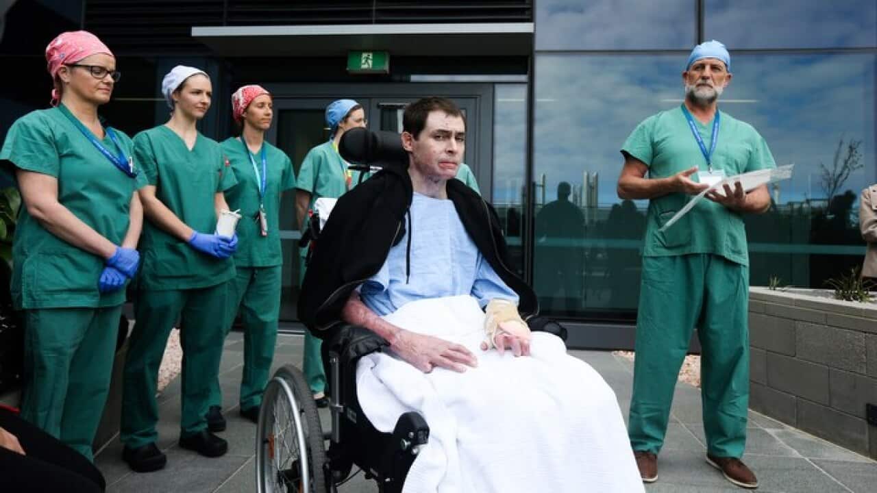 Burn patient and survivor Glenn Ogg (centre) poses with Dr John Greenwood (right) at the Royal Adelaide Hospital