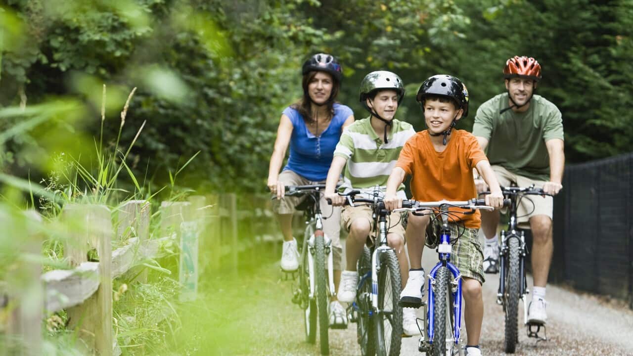 Family cycling in park
