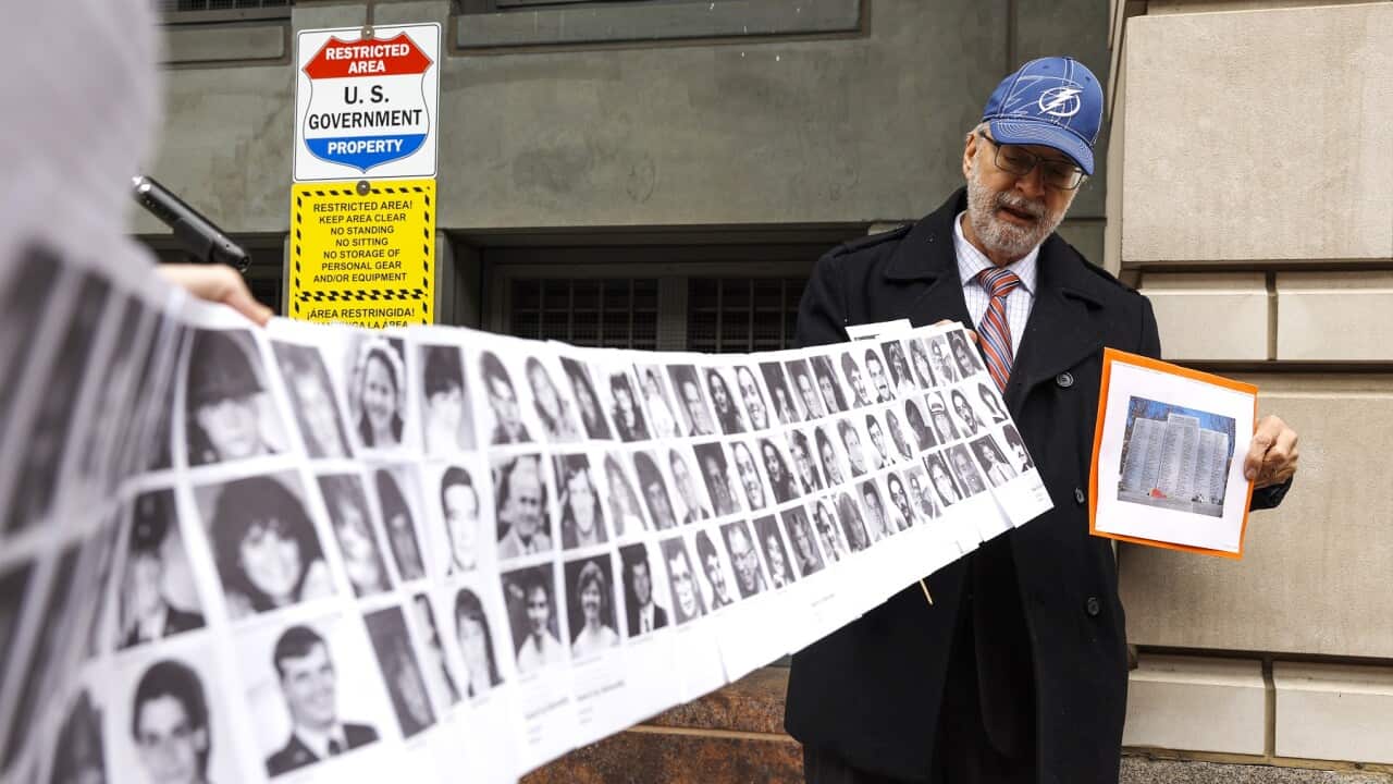 Paul Hudson holds up a banner of pictures of Lockerbie bombing victims