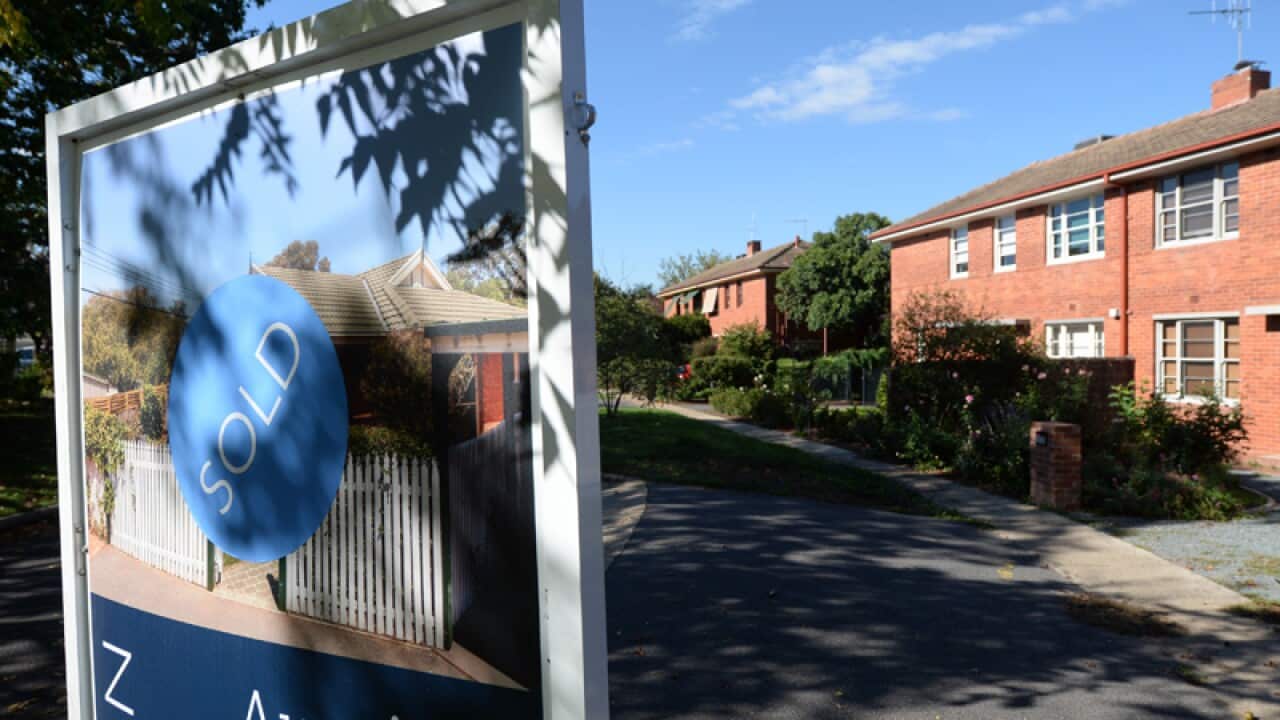 A sold sign is seen in front of a house in Canberra