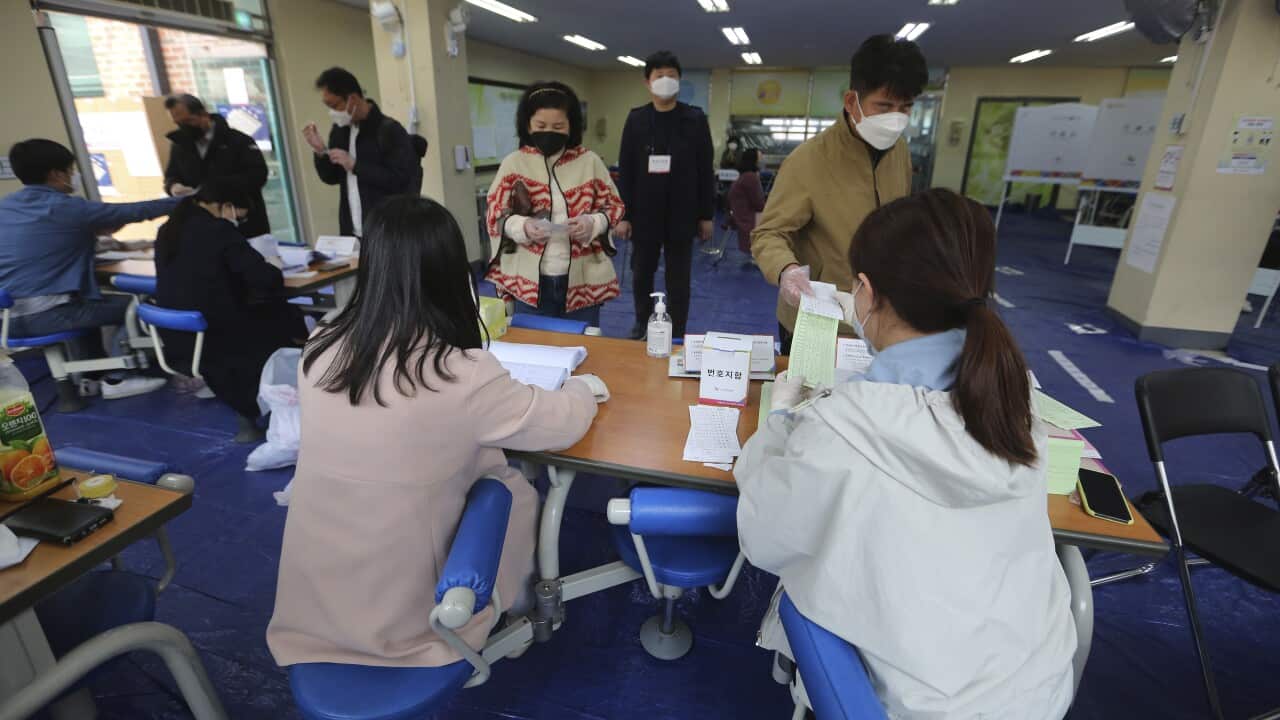 People wearing face masks to help protect against the spread of the new coronavirus arrive to cast their vote for the parliamentary election in Seoul